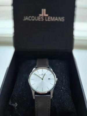 Jacques Lemans "Old money watch" - Riktigt stilren klocka från Jacques Lemans🙌 Urtavlan är silverfärgad o armbandet är mörkbrunt i äkta läder😁 Minimalistisk och URsnygg😎 Skyddsplast är kvar då klockan aldrig är använd👍 Vid minsta fundering skriv!! Org pris 1199, mitt pris 750💪