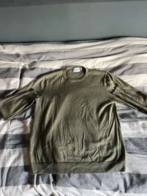 Olivgrön stickad tröja från Bläck - Olivgrön stickad tröja från Bläck i storlek L. Tröjan har rund hals, ribbade muddar och långärmade ärmar. Enkel och clean design som funkar till många olika stilar. Perfekt för dig som gillar neutrala färger och mjuka material.  Kom privat om du vill ha bild 