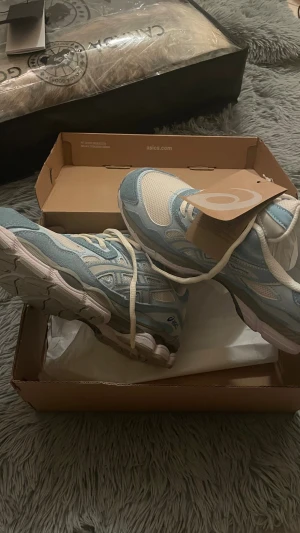 Asics skor funkar i vintern 🙌  - Fräscha Asics sneakers med snygg ljusblå och vit färgkombination. Ovandelen är i ventilerande mesh och mockadetaljer, med klassisk Asics-logga på sidan. Skorna har snörning och en robust, dämpad sula med GEL-teknologi för extra komfort.