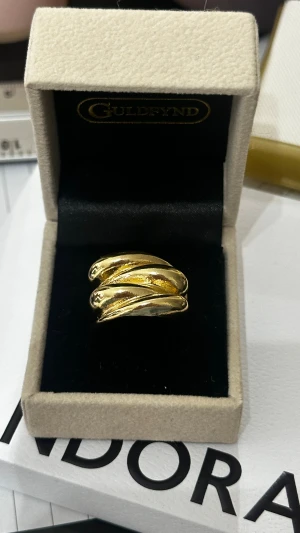 Guldpläterad ring - Snygg bred ring i guldpläterad metall med ett coolt, snirkligt och vågigt formspråk. Ringen har en glansig finish och känns riktigt lyxig och trendig. Perfekt för dig som vill sticka ut med ett statement-smycke.