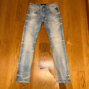 Replay Anbass ljusblå jeans - Replay Anbass jeans i ljusblå tvätt med snygga slitningar och skinny passform. Klassisk femficksmodell med dragkedja och knapp, samt Replay-logga på fickan. Perfekt för dig som gillar en modern och fräsch look. Pris kan diskuteras😄