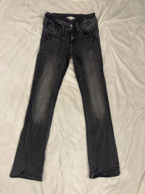 Grå  jeans från Gina Tricot - Gråa jeans från Gina Tricot med snygg tvättad look och kontrastsömmar. Klassisk femficksmodell, raka ben och dubbla knappar i midjan. Perfekta för dig som gillar en enkel men cool stil.