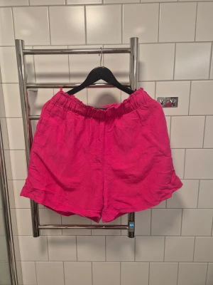 Rosa linneshorts med resårmidja - Säljer ett par chill rosa shorts i linnemix med bred resår i midjan. Modellen är loose fit och har bra fickor.