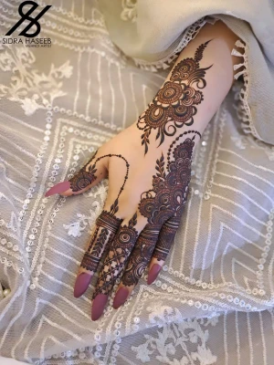 Henna konst med naturligt henna koner  - Unik henna konst på handen med detaljerade blommönster och cirklar, kombinerat med långa lila och glitter naglar. Designen är noggrant utförd och täcker både fingrar och handrygg, vilket ger en elegant och kreativ look.