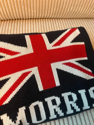 Blå stickad tröja Morris  - Mörkblå stickad tröja från Morris med Storbritannien flagga i rött, vitt och blått på bröstet samt Morris-tryck under. Klassisk rund halsringning med ribbade muddar. Perfekt för dig som gillar Fredde shiller från solsidan å letar efter en riktigt fet tröja storlek M men passar rätt bra även för S