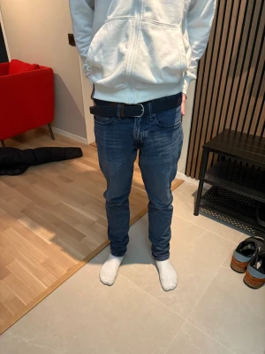 Blå jeans från Polo Ralph Lauren - Snygga blå jeans från Polo Ralph Lauren med klassisk femficksdesign och mörk tvätt. Jeansen har rak passform och normal midja, tillverkade i slitstarkt bomullsjeansmaterial. Perfekt för dig som gillar stilrena och tidlösa jeans. Sparsamt använda och i väldigt bra skick.   Nypris 2700kr