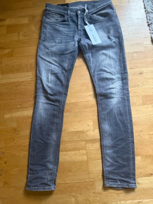 Grå dondup jeans  - Säljer ett par gråa dondup George jeans med snygg tvättad look. Perfekta för en clean och modern stil. Materialet är mjukt och stretchigt för extra komfort.