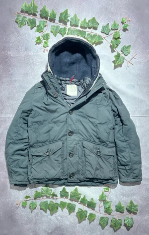 Moncler Martigues Giubio PufferJacka i Navy Storlek M [ÄKTA] - 🎨 Färg: Mörkblå / Navy 📏 Storlek: Moncler 3, (M) ♻️ Skick: 7.5/10 – minimalt slitage, inga synliga skador. inner dragkedja trasig, men vanliga fungerar normalt 🧵 Material: Tjock dunjacka med quiltad konstruktion ✨ Detaljer: • Varm och rejäl Moncler-dunjacka • Hög, ribbstickad krage med vita ränder • Dubbla frontstängningar: dragkedja + knappslå • Två stora frontfickor med lock och knappar • Moncler-patch på vänster överarm • Ribbstickade muddar vid ärmslut • Perfekt för vinterbruk