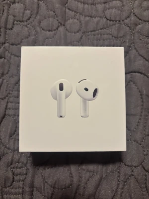 AirPods 4 - Säljer ett par helt nya Apple AirPods 4 med laddningsetui, kompatibla med USB-C laddare. Produkten är i nyskick, komplett med originalförpackning och tillbehör. Perfekt för trådlös musik och samtal med hög ljudkvalitet. Inga synliga defekter eller slitage.
