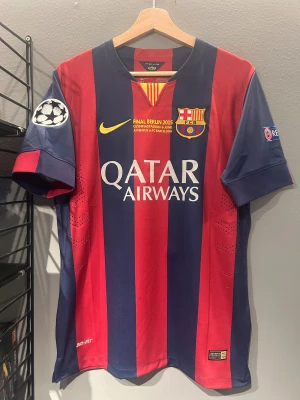 Barcelona Messi 2015 Final tröja S - Säljer en officiell FC Barcelona matchtröja från Champions League-finalen 2015 med Messi 10 på ryggen. Tröjan är kortärmad, har breda röda och marinblå ränder, gula detaljer och klubbmärke på bröstet. Dri-FIT material för bästa komfort. Qatar Airways tryck på framsidan. Helt ny med tagg en replika 