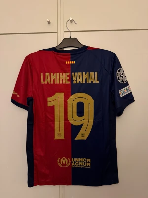FC Barcelona Lamine Yamal  - FC Barcelona fotbollströja med Lamine Yamal och nummer 19 på ryggen. 