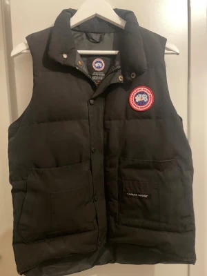 Svart dunväst från Canada Goose - Canada Goose väst som jag köpt för ett tag sedan. Kedjan funkar inte på västen så man måste knäppa den ist. Därför jag väljer att sänka priset!