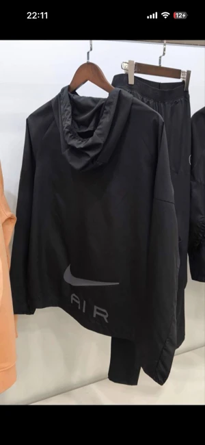 Svart Nike Air träningsset med huva - Säljer ett svart träningsset från Nike Air med matchande hoodie och byxor. Hoodien har huva, dragkedja och stor Nike-logga på ryggen. Byxorna har resår i midjan och diskret logga på benet. Perfekt för dig som vill ha en clean och sportig look.