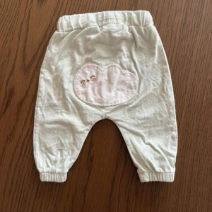 Söta bebisbyxor  - Ljusblåa söta bebisbyxor med ett moln från Newbie i storlek 50. Fint skick.