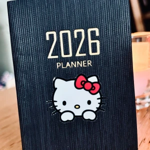 Svart fickalmanacka för 2026 med Hello Kitty-motiv! - Svart fickalmanacka för 2026 med Hello Kitty-motiv. Mått: 10 x 8 cm. Ny och oanvänd.