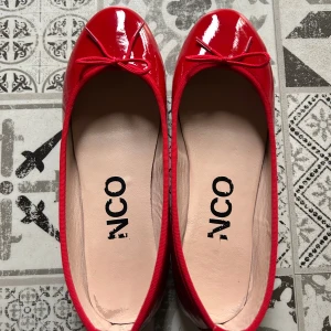 Röda ballerinaskor från Bianco, strl 37 - Röda ballerina skor från Bianco i mjukt lammskinn. Endast använda två gånger och i mycket fint skick, utan märken eller skador, bara lite tecken på användning på insidan. Storlek 37, men de är små i storleken.( Står på deras hemsida) Kartong medföljer vid köp, om man vill såklart.  Pris kan diskuteras, först till kvarn ! ❤️  Klackhöjd: 1 cm  Innermaterial: 55% Nylon, 45% Polyuretan; Ovandelsmaterial: 100% Lammskinn; Sulmaterial: 100% Termoplastgummi; Innersula: 100% Getskinn
