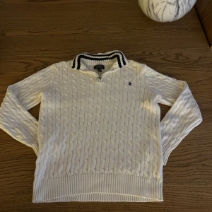 Vit kabelstickad Polo Ralph Lauren tröja  - Tja säljer en kabelstickad polo tröja. Den är bokstavligen aldrig använd fick den i födelsedagspresent men har aldrig kommit till användning. De står XL men de är i ungdoms storlek så skulle säga att den passar bra om du är 165-170. Bara fråga om ni har några funderingar😁😁