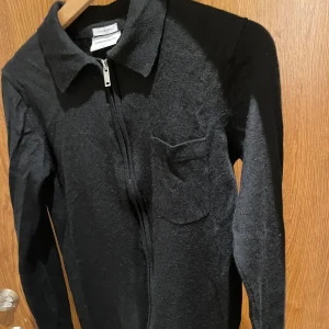 Svart merinoullskofta från Lindbergh - Nästan helt ny || Svart kofta från Lindbergh i mjuk merinoull. Modellen har lång ärm, klassisk krage, bröstficka och hel dragkedja framtill. Perfekt ni för vintern och hösten || Hör av er vid minska lilla || 