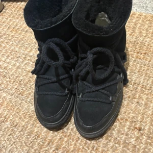 Svarta INUIKII skor - Säljer ett par svarta vinterskor från INUIKII. Dem är använda mycket en hel vinter därför är dem inte i nyskick. Sulorna inuti inte i det bästa skicket men det går bara att köpa en sula och lägga i. Bild 3 visar där fodret på hälen har nötts bort. Trots att dem är använda en del så är dem ändå fina på utsidan och inga hål eller stora fläckar. Vissa små defekter finns men inga man tänker på vid användning. Det är storlek 40 men skulle säga att det passar 39/40.     Pris kan diskuteras 