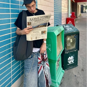 Bravest studios  - Säljer ett par riktigt baggy denimshorts i grått med stor Union Jack-flagga och Jesus-tryck på ena benet. Shortsens look förstärks av en silverfärgad kedja i midjan. Perfekt för dig som gillar streetwear och statement-plagg.