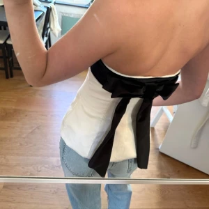 Vit och svart tubtopp med rosett från Zara - Supersnygg tubtopp från Zara i vit med svart sammetsband upptill och stor rosett bak❤️