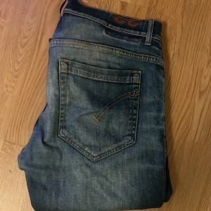 Dondup - Säljer ett par blå skinny fit jeans från George i storlek 33. Jeansen har slitna detaljer på benen, klassisk femficksdesign och kontrastsömmar. Perfekta för dig som gillar en smal passform och en lite ruffare look.