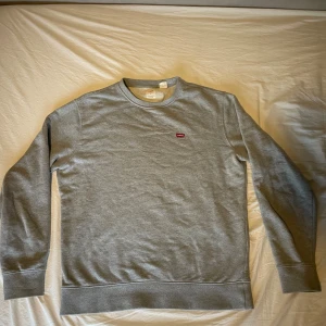 Grå kofta från Levi's - Säljer nu en stilren grå kofta från Levi's i storlek M. Tröjan har rund halsringning, lång ärm och en liten röd Levi's-logga på bröstet. Den har används kanske 1 gång. Det är bara att skriva vid funderingar mvh William  