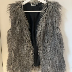 Grå pälsväst från Noisy May - En såå fin pälsväst i grå, perfekt att ha till vardags eller fest! 🥰använd fåtal gånger 
