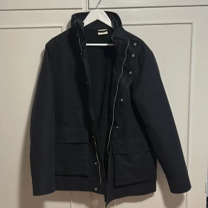 Mörkblå vindjacka från Gant - Jag säljer en otroligt snygg dubbeljacka av märket Gant som passar perfekt nu till höst/vinter. ”Underjackan” går enkelt att sätta på eller av och kan användas enskilt eller tillsammans med den andra delen under kallare dagar. Jackan är i princip oanvänd då jag endast testat den hemma men ej utomhus men prislapp sitter dock inte kvar. Jag kan även tänka mig sälja delarna separat. Tveka inte på att höra av dig om du några frågor eller funderingar!  Nypris:5500 kr