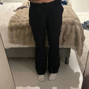 Svarta kostymbyxor med raka ben - Säljer för dem ej kommer till användning. Men super fina och sitter perfekt på. Köpta för 650 kronor för ett tag sen men som nya. Använda få gånger. (min spegel är smutsig inte byxorna) Säljer ett par svarta kostymbyxor med raka ben mer åt bootcut och midwaist passform. Byxorna har hällor för bälte och diskreta bakfickor. Perfekta för en clean och stilren look. Materialet känns mjukt och följsamt, vilket gör dem riktigt bekväma att bära. 🥰🥰