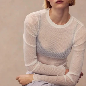 Vit ribbad långärmad topp H&M - Säljer en tunn, vit långärmad topp med ribbad struktur och tight passform. Toppen är genomskinlig och har en rund halsringning samt vågiga kanter vid ärmslut och nederkant. Perfekt att styla lager på lager eller med ett snyggt linne under.