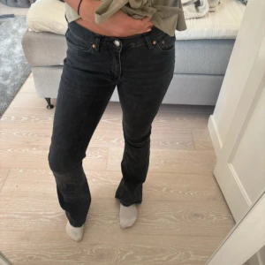 Svarta bootcut jeans  - Snygga svarta jeans med klassisk femficksdesign och bootcut-ben. Jeansen har en normal passform och är tillverkade i mjukt denimtyg som sitter skönt på kroppen. Perfekta för dig som gillar en tidlös och stilren look.