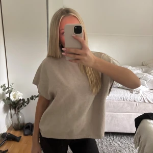 Beige stickad ärmlös tröja - Säljer en beige stickad tröja med lös passform och breda ärmhål. Tröjan är ärmlös och har en enkel, stilren design med ribbade kanter. Skriv för fler frågar eller funderingar. Storlek M men passar även mig som är S🩷