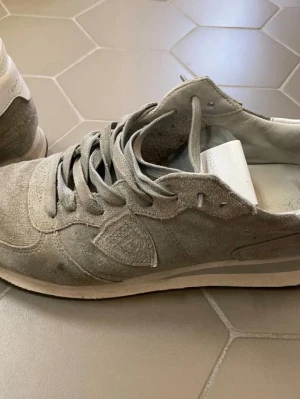  Philippe Model - Säljer ett par snygga sneakers från Philippe Model i militär grön mocka med vita detaljer på hälen. Skorna har klassisk snörning, rund tå och platt sula. Perfekta för dig som gillar stilrena och tidlösa sneakers med en lyxig känsla. Skicket är bra, först till kvarn! Pris kan diskuteras och fler bilder kan självklart tas skorna är stora i storleken och passar 40 och 41 också mvh Theodor!
