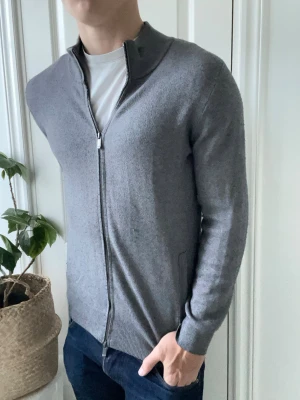 Massimo dutti full zip grå  - Massimo dutti full zip, inga större defekter. Modellen är 180 cm 75 kg och bär storlek S. Kom med frågor! Sittter väldigt fint runt kroppen och är en favorit! 