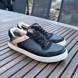 Burberry skor - Burberry sneakers i grymt skick. Enda defekten är att ett par burberry  bokstäver lossnat vid skosnöret, men det är inget man märker. Nypris: 6000, mitt pris: 1500. Storlek 42