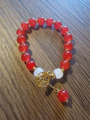 Armband med röda och vita pärlor - Ett vackert armband med röda och vita pärlor, samt guldfärgade detaljer.Perfekt för att komplettera din stil.