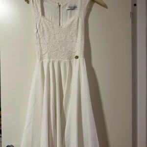 Vit spetsklänning från Chiara Forthi- studentklänning - Supersöt vit klänning från Chiara Forthi med spetsliv och v-ringning. Kjolen är flowy och har ett mjukt fall. Klänningen är ärmlös och har dragkedja i ryggen för enkel påklädning. Perfekt för sommarens alla tillfällen! Väldigt fin till student !!