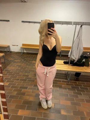 Svart figurnära body - Säljer en svart, stilren body med smala axelband och djup v-ringning. Bodyn är figurnära och har en enkel, clean look som passar till både jeans och mjukisbyxor. Materialet känns mjukt och stretchigt, perfekt för en trendig och avslappnad outfit. Köpte för ca 209 och använt 2 gånger 