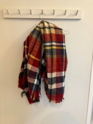 Rutig väst i mjuk bomull - Säljer en färgglad rutig väst i mjuk bomull. Västen har stora rutor i rött, marinblått, vitt, gult och beige. Perfekt för dig som vill sticka ut med ett klassiskt rutmönster och sköna höstfärger. Passar till lager på lager och ger en avslappnad vibe. 140x140cm