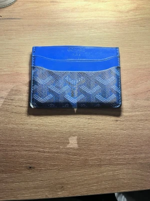 Blå plånbok  - Säljer en blå plånbok i helt okej skick men för ett bra pris 😅 du kan se skadorna på bilderna 3 och 4. Den är randig och passar till mycket ! Bara komma med frågor om det behövs 👍kommer med box 