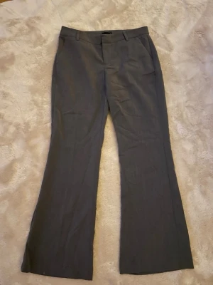 Grå kostymbyxor  - Fina grå kostymbyxor från Gina! Modellen är låg midja wide! Sitter långt på mig som är 170 💕💕Aldrig använda nypris 400! 