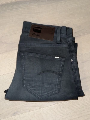 G-star raw 3301 - Jag säljer ett par G-star raw jeans i modellen 3301 helt nytt skick, sitter slim på benen och bra i längden dom är i färgen grå men är nästan svarta, hör av er vid minsta fundering!
