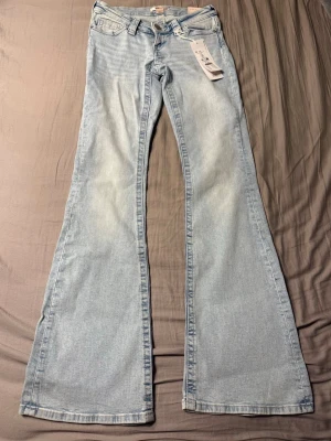 Jeans från Gina Young 14+ - Ett par blå lågmidjade bootcut jeans med detaljer på fickorna från Gina Tricot Young 14+ i storlek XS. Dem är helt nya🩷🩷