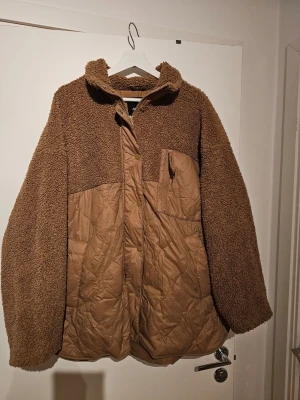 Beige teddyjacka med quiltade detaljer - Säljer en beige teddyjacka med quiltade partier framtill och baktill. Jackan har hög krage, dragkedja och tryckknappar samt en bröstficka med dragkedja. Materialmix av mjuk teddy och quiltad polyester ger en riktigt chill look.