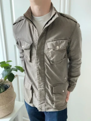 Woolrich jacka  - Woolrich field jacket brun, i storlek L. Det är ganska många små revor omkring jackan som jag ej vet är design eller ej. Men den är iaf i väldigt använt skick men har liksom inga större defekter som förstår själva användningen av jackan ❣️, väldigt snygg och eftertraktad jacka. Modellen är 180 cm 75 kg kom med frågor 🙏