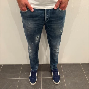 Dondup Jeans George  - Dondup Jeans George! Trendigaste jeansen på marknaden.  Skick= 9,5/10 Ny pris= 4000 kr Säljs för= 999 kr, 34 midja 35 längd, jeansen är uppsydda (Modellen har original slitningar från fabrik vilket är väldigt eftertraktat och populärt)