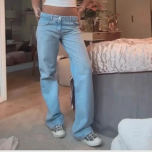 Ljusblå raka jeans med normal midja - Säljer ett par ljusblå jeans med raka ben och klassisk femficksdesign. Jeansen har normal midja och är tillverkade i mjukt denimtyg. Storlek 34 och aldrig använt. Pris kan diskuteras!!