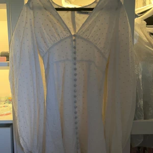 Vit klänning från Adoore - Supersöt kort vit klänning med långa ärmar från Adoore. Säljer då den tyvärr var för liten.