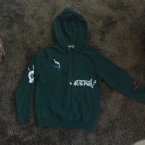 Mörkgrön hoodie från Zadig & Voltaire - Skitsnygg mörkgrön hoodie från Zadig & Voltaire med coola vita och blå grafiska tryck på bröstet och ärmarna. Aldrig använt säljer då den förtjänar att komma till användning!!! Verkligen så snygg å unik! Kan tänka mig gå ner i pris vid snabb affär